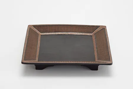 The dark black lacquered center of the Ming Dynasty tray, surrounded by an elegant basket weave design, made it seem almost modern.