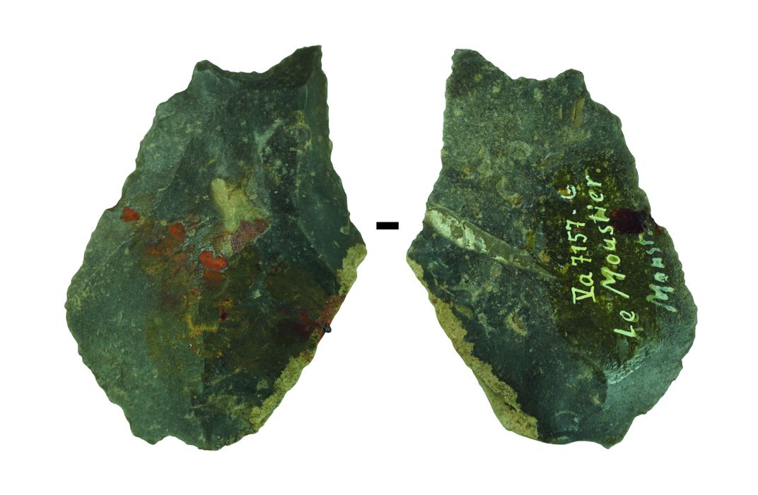the front and back of a stone artifact, with traces of an orange substance