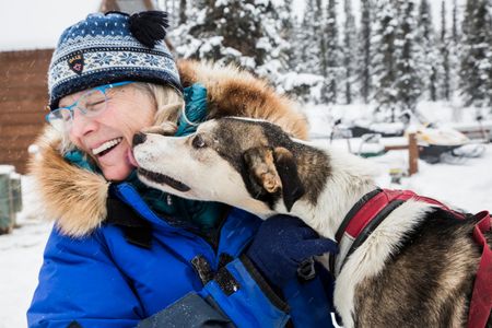 Iditarod racer Debbie Moderow enjoys a moment with Crouton, one of 28 Alaskan husky sled dogs she currently trains at the Salty Dog Kennels.