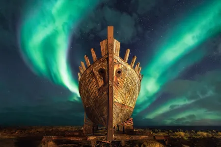 An old Viking ship under the Northern Lights in Iceland