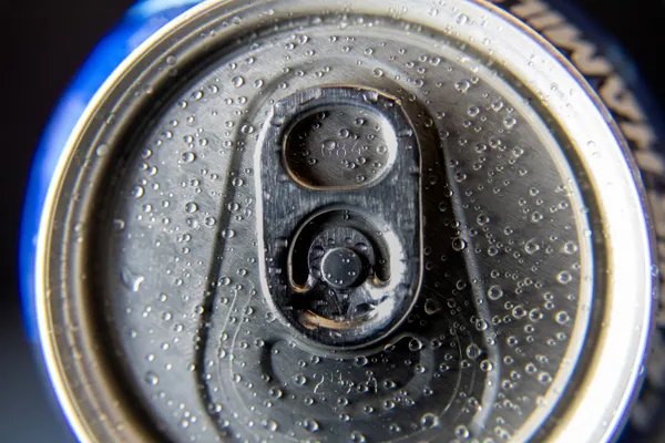 A metallic canvas kissed by the storm. Rainwater droplets trace patterns on the cold aluminum lid. thumbnail