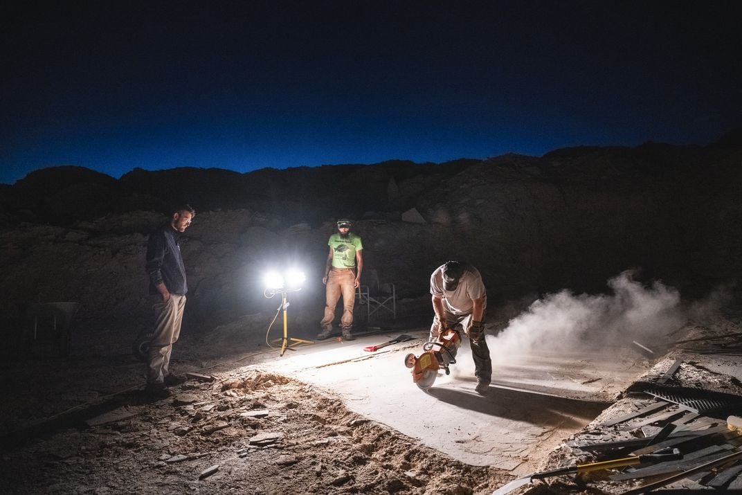 Rick Hebdon uses a stone saw to isolate a fossil during a night dig at his quarry on fossil ridge.