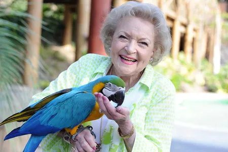 Betty White poses with a parrot at the Los Angeles Zoo in 2014.
