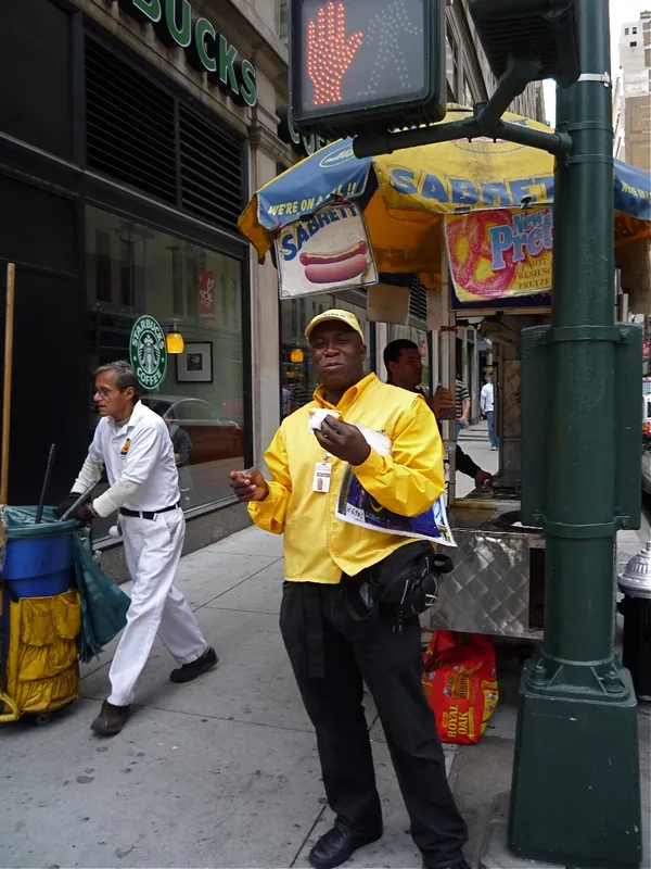 Nigerian man eating a hot dog in New York City thumbnail