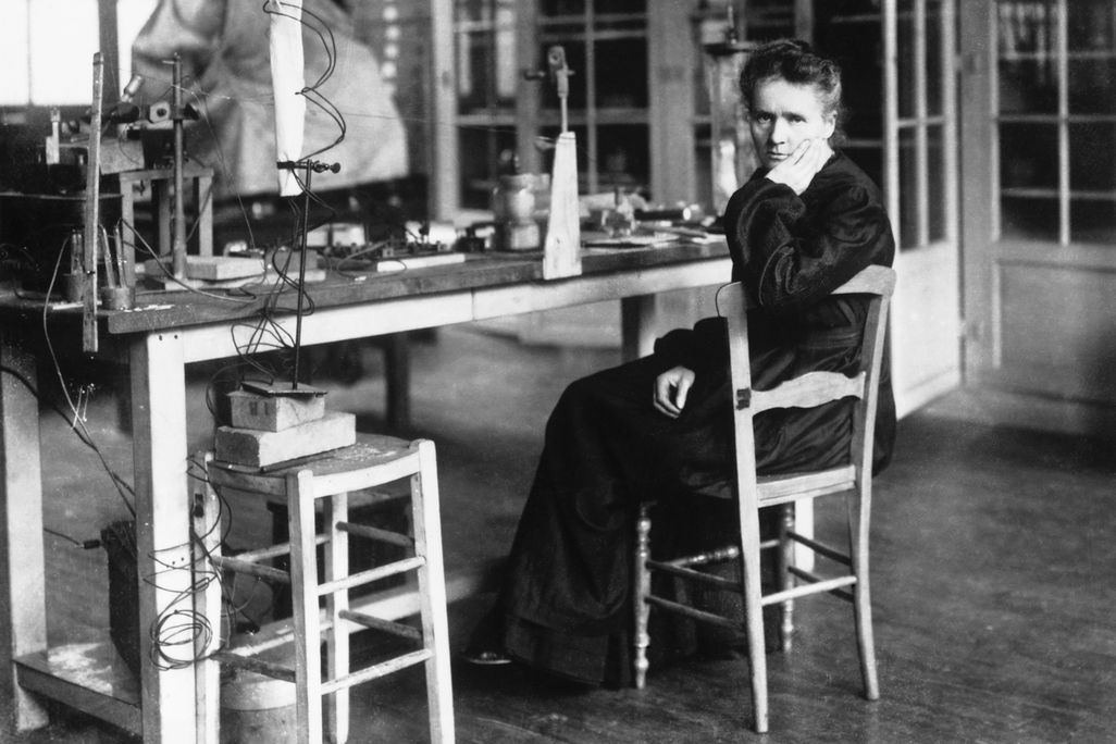 Black and white photo of a woman sitting in a chair in a laboratory