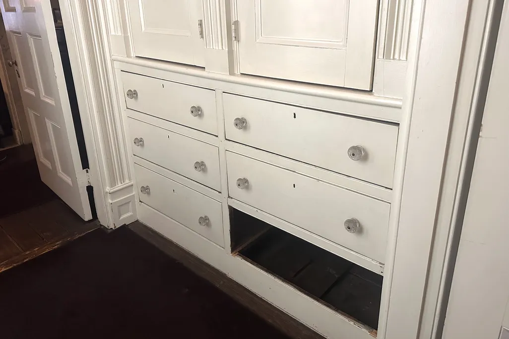 An old wooden dresser with a false drawer that leads to a secret passageway