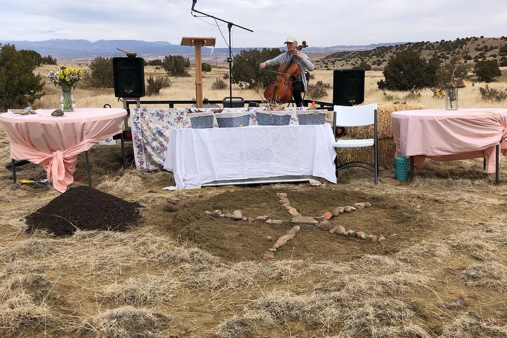 Composted human remains with a cello player in the background at a laying out ceremony