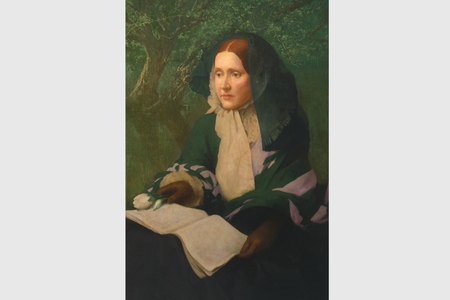 Julia Ward Howe posed seated with a book open on her lap.