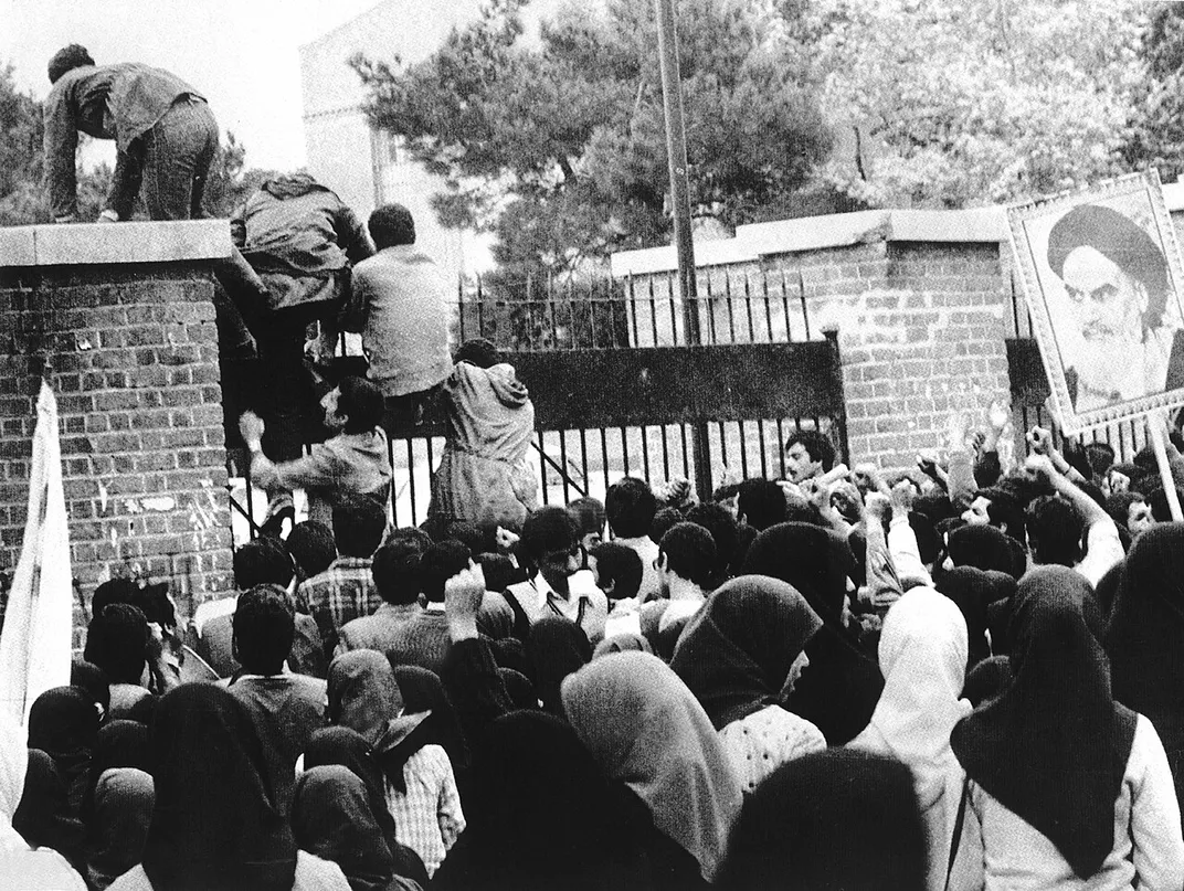 Iranian students climb over the U.S. Embassy gates in Tehran during the 1979 hostage crisis.