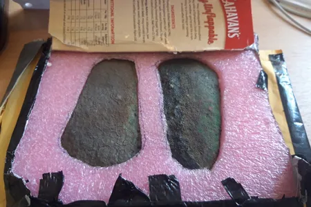 The anonymous sender secured the artifacts in foam cut-outs inside a cardboard flapjack box.