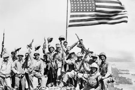 United States Marines pose on top of Mount Suribachi on the island of Iwo Jima with the American flag on February 23, 1945.