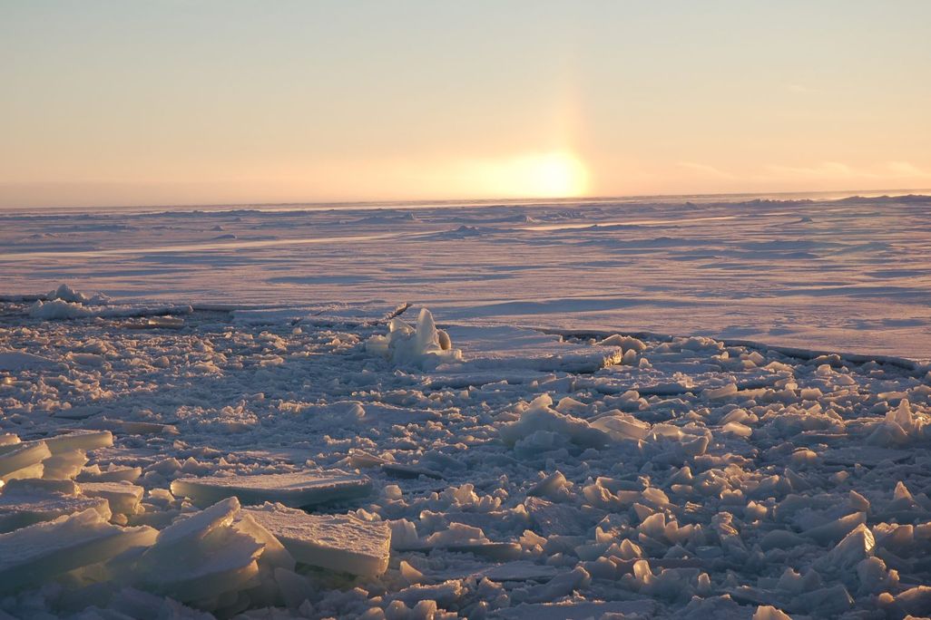 An image of sea ice in the Canadian Arctic Archipelago. The sun is setting in the background.