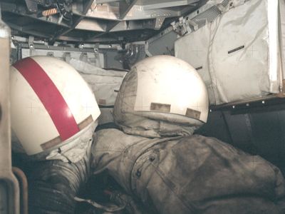 Two Apollo EVA spacesuits, covered in dark gray lunar dust. The short times spent on the Moon by the Apollo astronauts meant that the long-term issues associated with dust could be ignored during those missions.