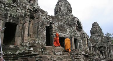 Saffron-robed monks enter the Bayon, which stands in the precise center of the King Jayavarman VII's temple city of Angkor Thom.