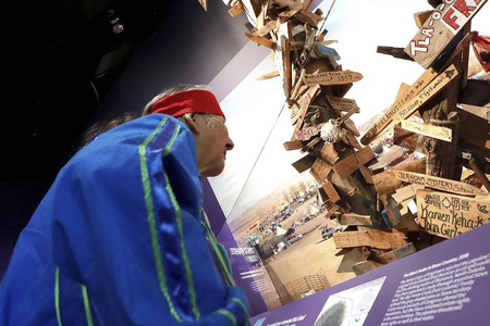 John Richard Edwards (Onondaga) takes part in the installation of the mile-marker post from the Dakota Access Pipeline in the exhibition 