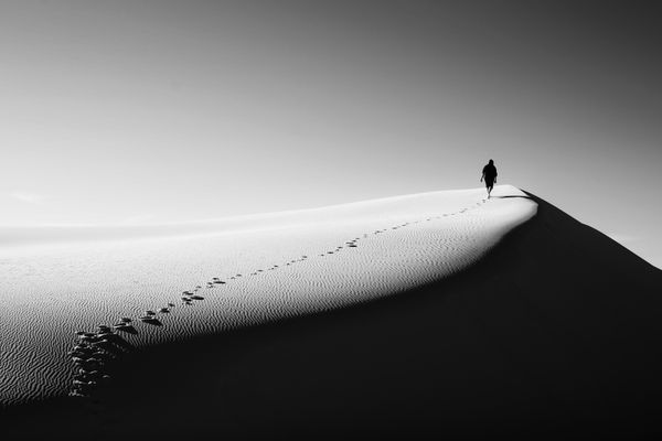 Lone girl walking over gypsum sand dune in White Sands Natl Monument, Alamogordo, New Mexico. thumbnail