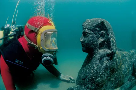 Archaeologist eye to eye to with a sphinx underwater, Eastern Harbor, Alexandria, Egypt, 1st century BC; granodiorite; 27 9/16 x 59 1/16 inches; National Museum of Alexandria (SCA 450); IEASM Excavations; Photos: Jèrôme Delafosse © Franck Goddio / Hilti Foundation.