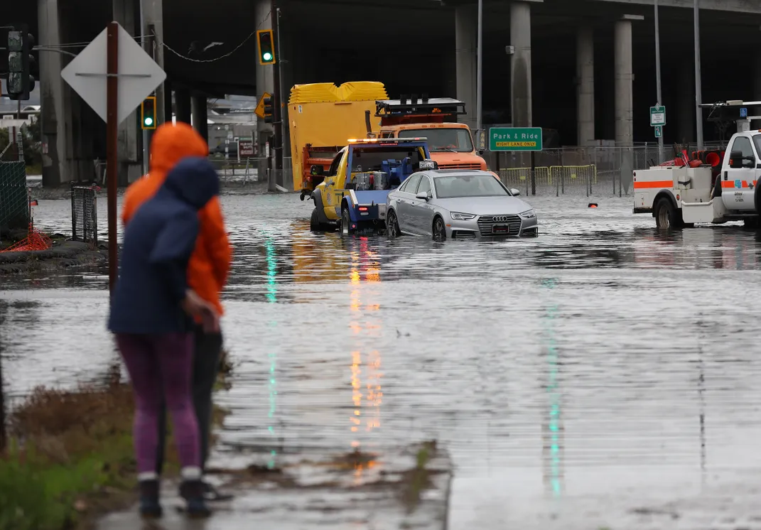 Flooded street with cars and people