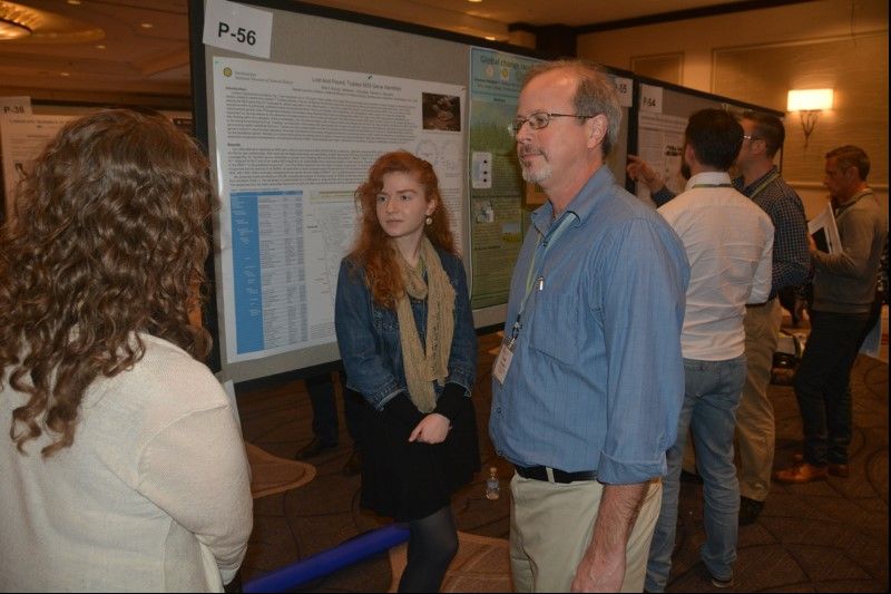 A group of people in front of posters.