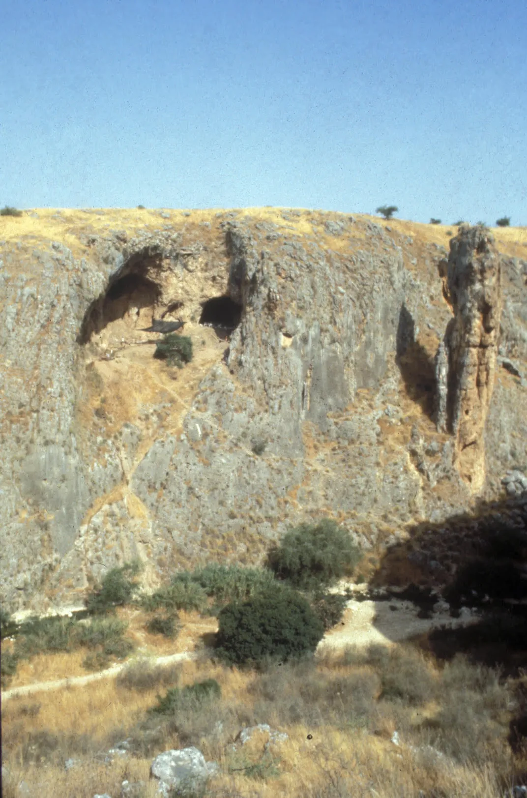 A rocky cliff with a cave