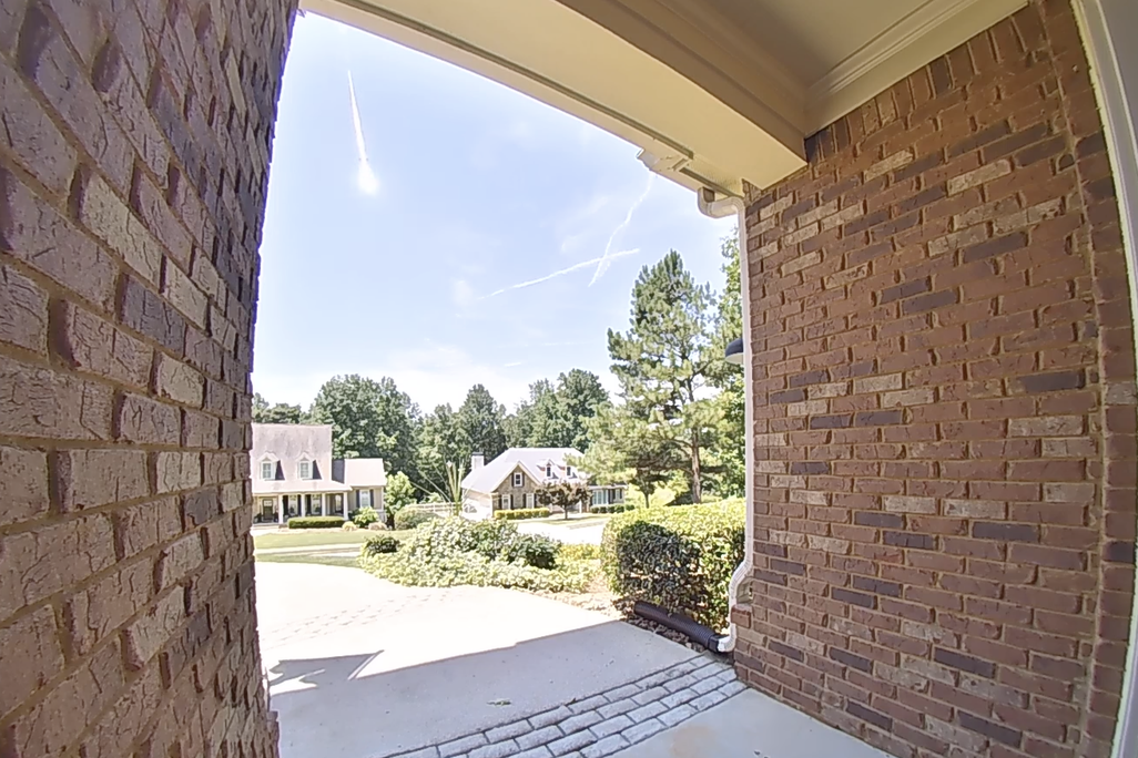 a bright streak in the sky as seen from a doorbell camera in a residential neighborhood