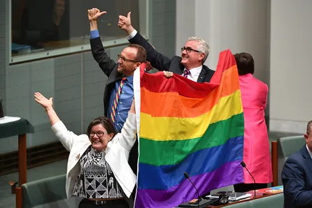 Members of parliament react to the passage of the Marriage Amendment Bill, from left to right, Cathy McGowan, Adam Brandt and Andrew Wilkie.