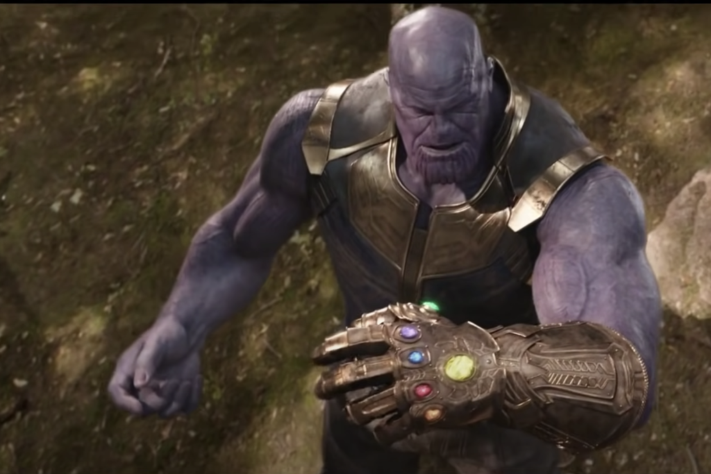 Thanos, a villain in the Marvel universe is a giant, burly purple man wearing gold armor. He wears the Infinity Gauntlet, a large metal glove with six colorful stones embedded—on his left hand.