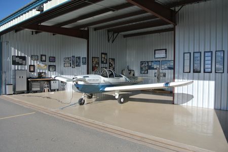 The author’s 1947 Ercoupe 415‑CD at home in its New Mexico hangar, decorated with framed Ercoupe images taken from advertisements and magazine covers.