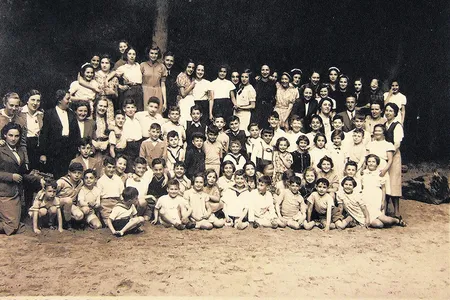 Child refugees from Germany and Austria at the Amsterdam Burgerweeshuis orphanage. Truus Wijsmuller stands at far left, looking at the children she helped save.