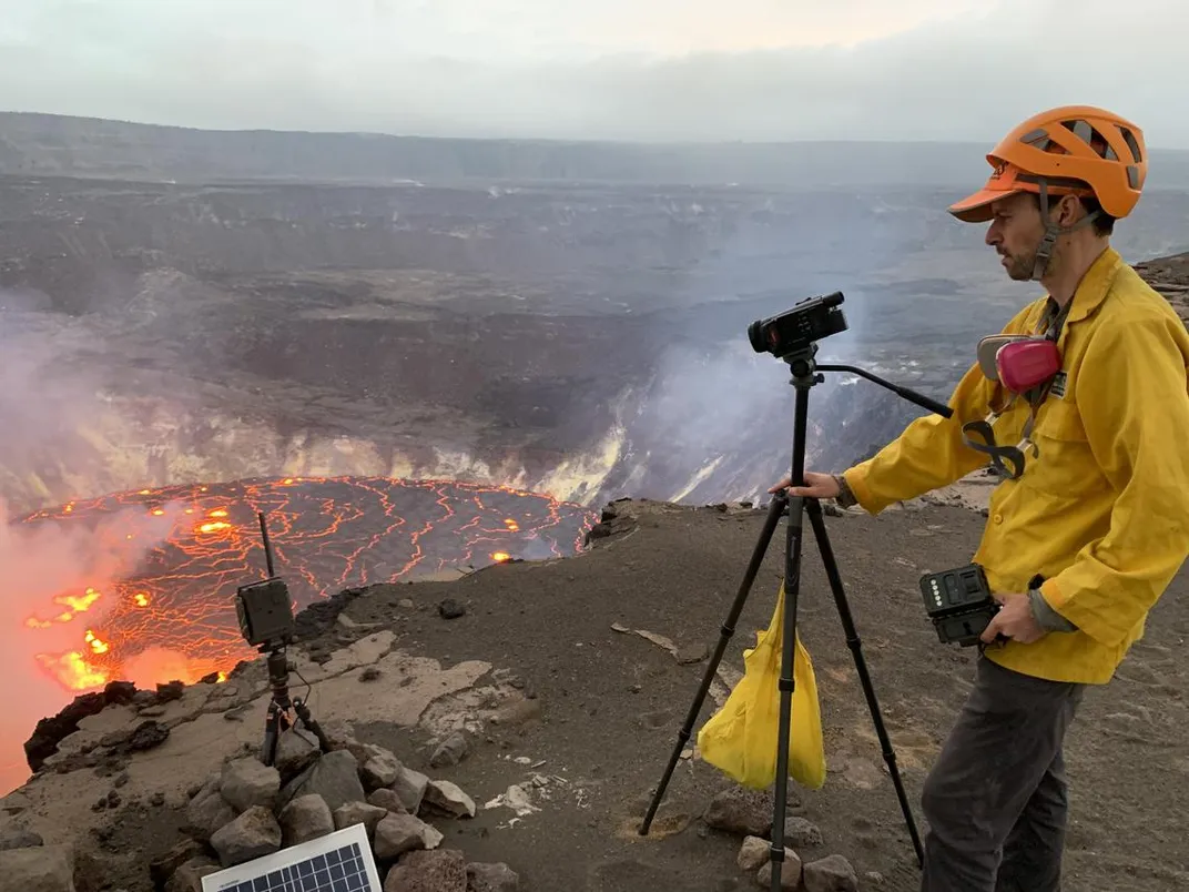 An image of a geologist taking photos and video of the eruption that started within Halema'uma'u crater on the Kīlauea summit