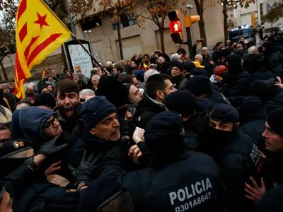 Catalan Mossos d'Esquadra officers scuffle with demonstrators as they cordon off the area around Lleida museum in the west of Catalonia, Spain, on Monday, Dec. 11, 2017.