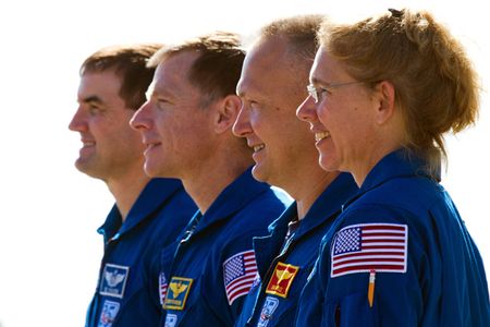 The crew of STS-135, from right, Sandy Magnus, Doug Hurley, Chris Ferguson and Rex Walheim pose for a group photo as the space shuttle Atlantis is moved from the Orbiter Processing facility to the Vehicle Assembly Building at the Kennedy Space Center on Tuesday, May 17, 2011, in Florida. The move, known as rollover, is a milestone in the preparation for launch as the orbiter leaves its processing hangar to be prepped for its final flight. ( NASA Photo / Houston Chronicle, Smiley N. Pool ).
