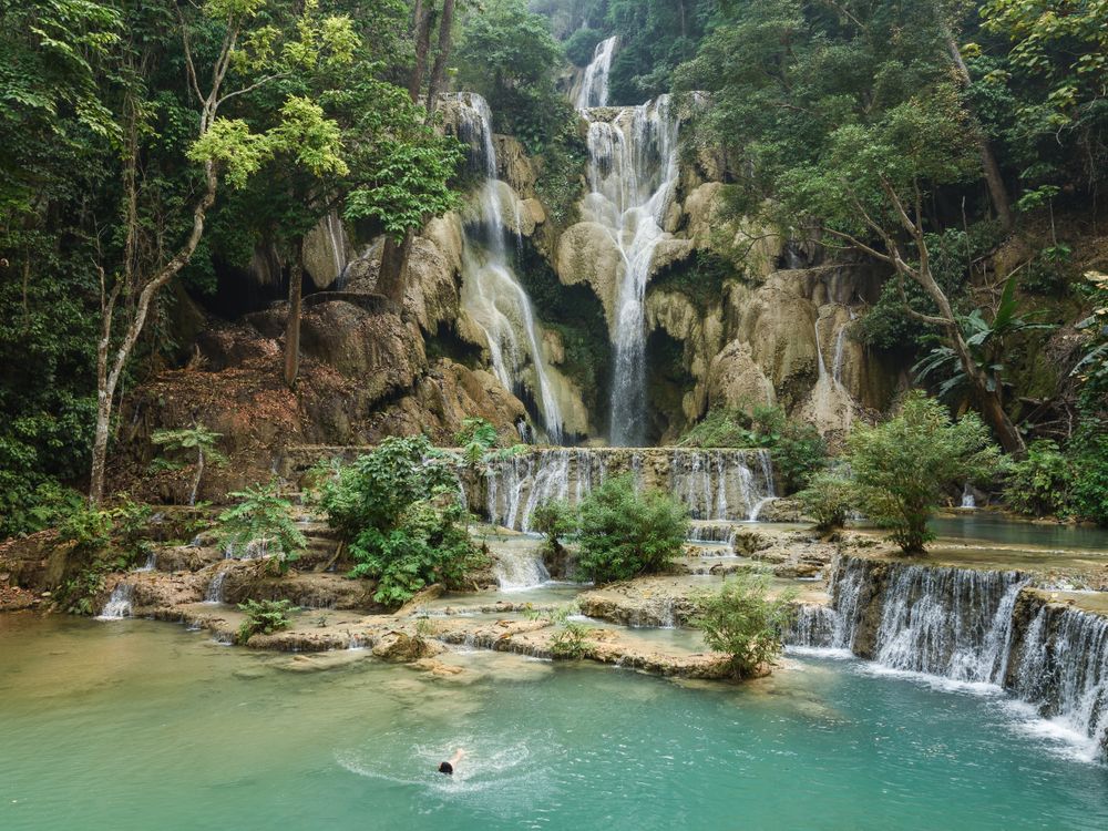 Kuang Si is a multi-tiered waterfall fuelling a stream that forges a turquoise passageway through the Laotian rainforest. It is popular with locals and tourists alike for cool swims on hot days.