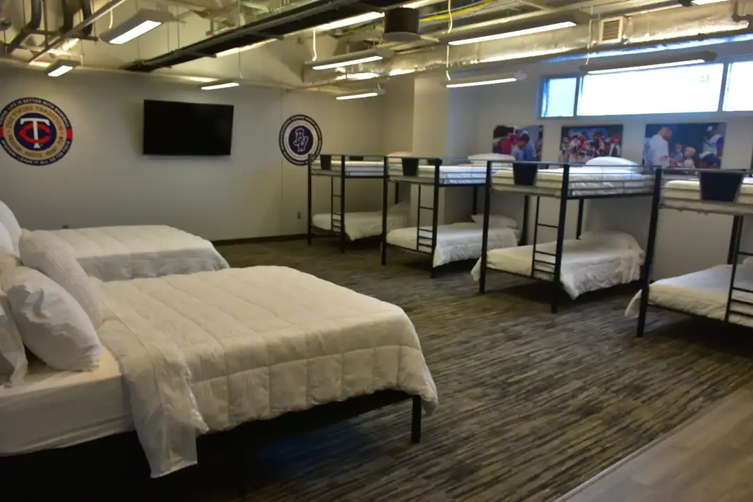 Two queen beds near four bunk beds in room