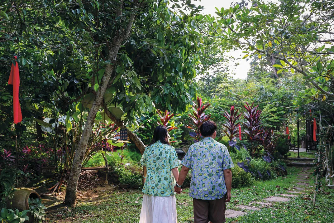 people in Durian patterned shirts walk hand in hand.