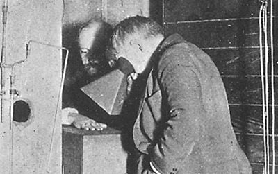Thomas Edison examines Clarence Dally's, his assistant, hand thru a fluoroscope of his own design.
