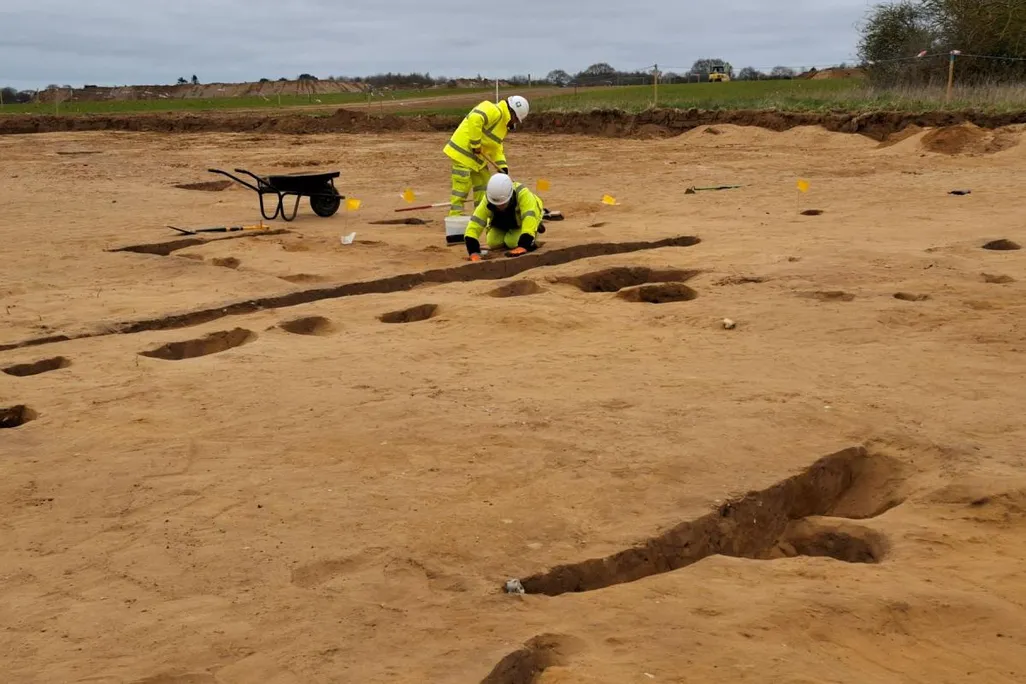 Archaeologists digging in dirt