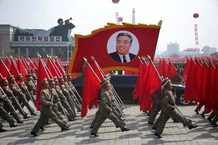 North Korean soldiers carry flags and a photo of late leader Kim Il-sung during a military parade on Saturday, April 15, 2017, in Pyongyang, North Korea.