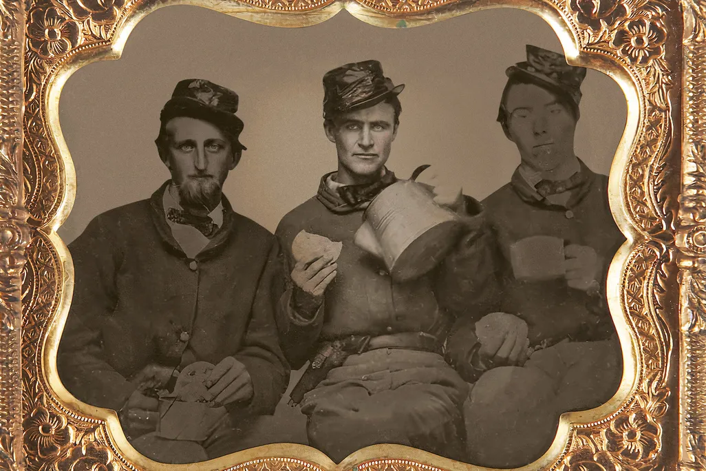 Union soldiers sit will coffee and bread in a portrait