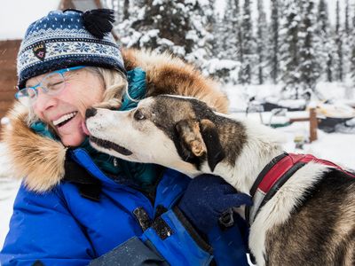Iditarod racer Debbie Moderow enjoys a moment with Crouton, one of 28 Alaskan husky sled dogs she currently trains at the Salty Dog Kennels.
