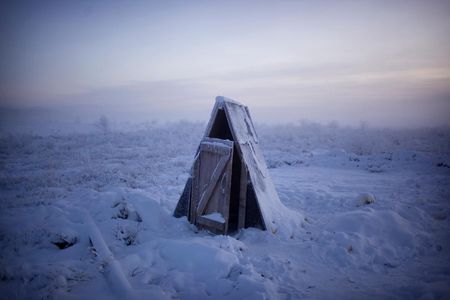 A toilet on the tundra at a gasoline stop on the road to Oymyakon. A sharp spire of frozen excrement rose almost to ground level from the pit beneath. 