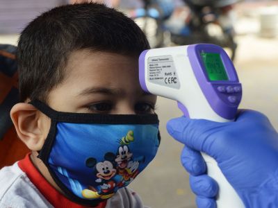 A doctor checks the temperature of a child at a mobile clinic.
