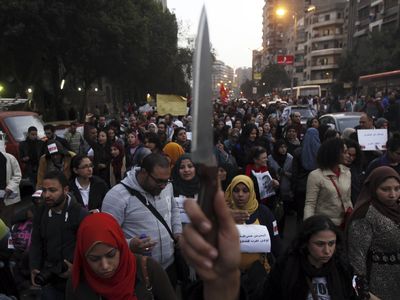A woman raises a knife and shouts slogans against then Egyptian President Mohamed Mursi and the Brotherhood during a march against sexual harassment and violence against women in Cairo, February 6, 2013. 