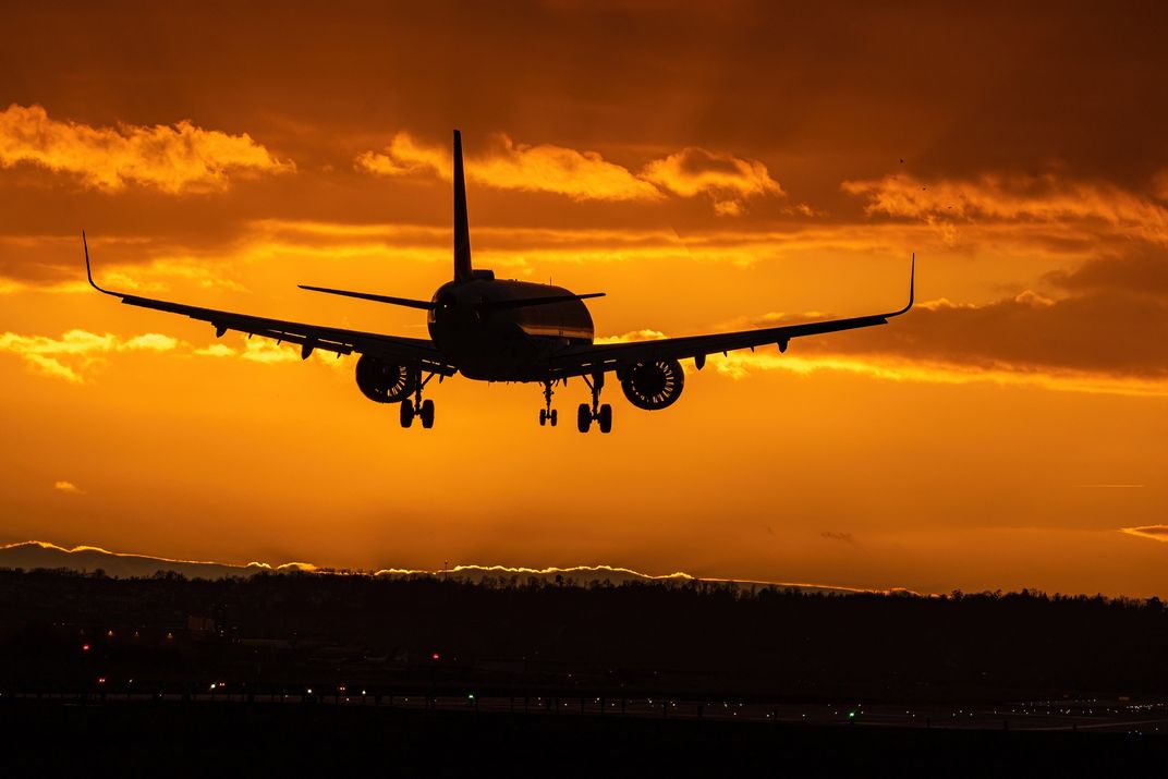Airplane flying at sunset