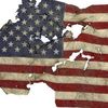 A tattered, torn, and singed American flag displayed against a white background.