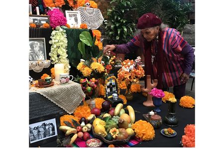 Doña Ofelia Esparza decorates the ofrenda 