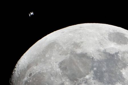 The International Space Station can be seen as a small object in upper left of this image of the moon in the early evening Jan. 4 in the skies over the Houston area flying at an altitude of 242.8 miles. 