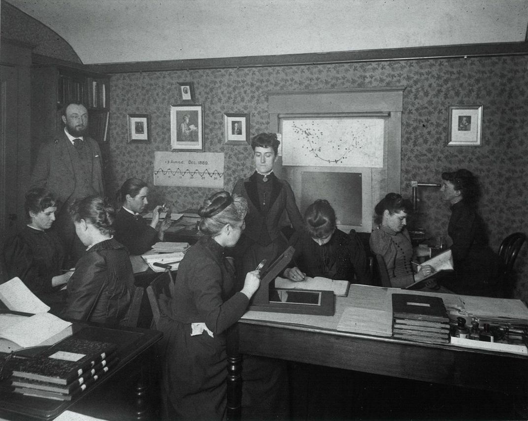 Women working as computers examine photographs of stars for astronomical data