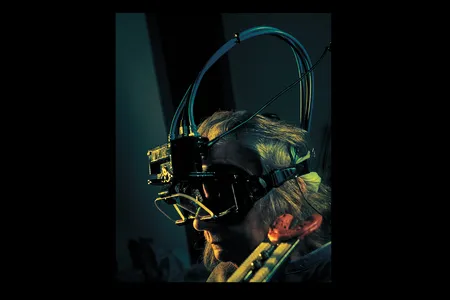 The patient looks through measuring goggles at a series of markers on a grid.&nbsp;