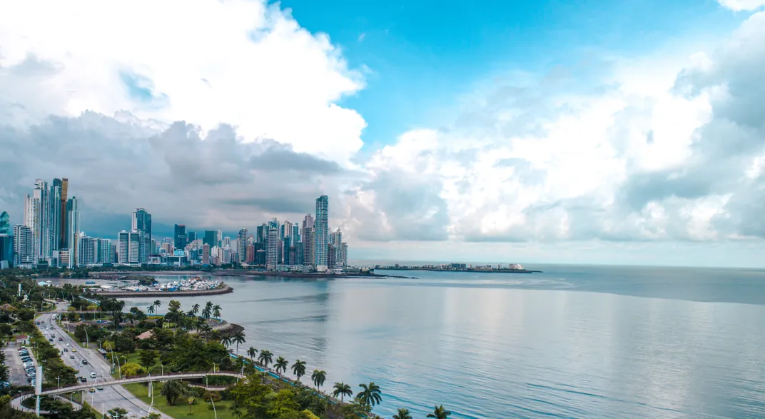 The roads and high rises of a coastal Panamanian city juxtaposed against the vast ocean